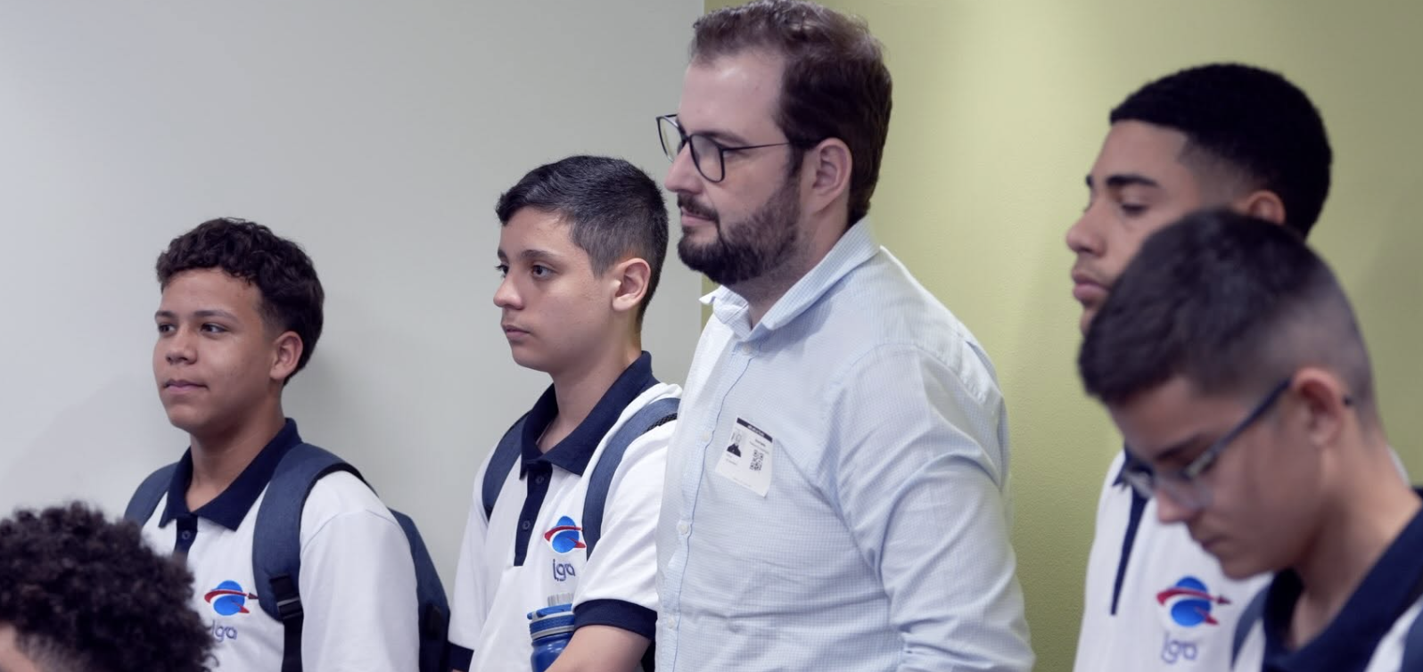 Bruno Santos ao lado de estudantes em sala de aula